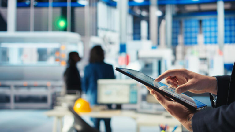 Consultoria de marketing para indústria: profissionais usando tablet em ambiente industrial.