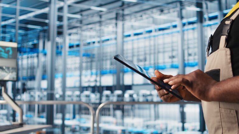 Marketing digital para indústria: pessoa usando tablet em uma fábrica moderna