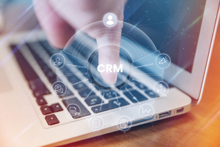 Integração marketing e CRM: notebook no fundo e ícones simbolizando CRM.